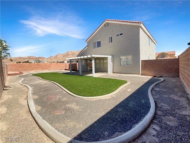 6696 Merced Lake Dr, Las Vegas, NV 89156 - back of property with a fenced backyard, stucco siding, a patio area, and a mountain view