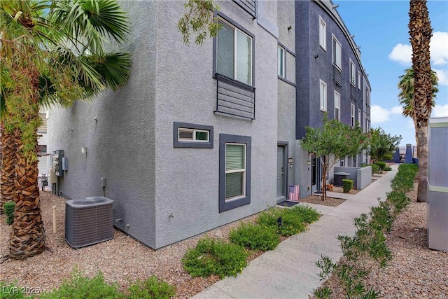 9050 W Tropicana Ave Unit 1027, Las Vegas, NV 89147 - view of side of home with stucco siding and a central AC unit