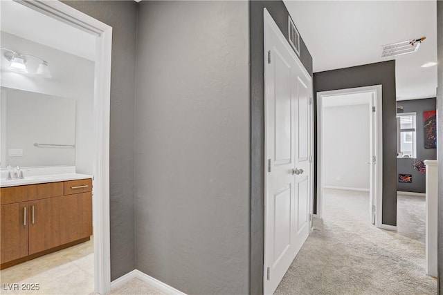 9050 W Tropicana Ave Unit 1027, Las Vegas, NV 89147 - hallway featuring light carpet and a sink