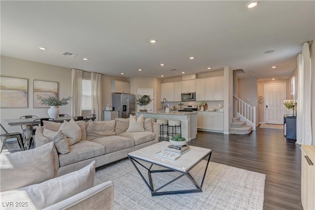 7705 Alder Forest St, Las Vegas, NV 89113 - living room with dark wood finished floors, recessed lighting, and stairway