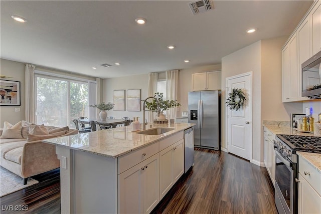 7705 Alder Forest St, Las Vegas, NV 89113 - kitchen with stainless steel appliances, dark wood finished floors, light stone counters, white cabinets, and recessed lighting