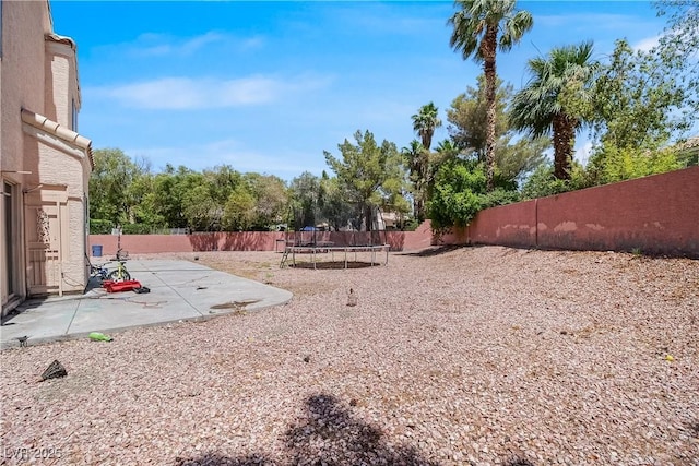 2500 Cortina Ave, Henderson, NV 89074 - fenced backyard featuring a trampoline and a patio area