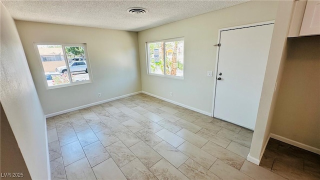 4238 Boratko St, Las Vegas, NV 89115 - empty room with plenty of natural light, light marble finish flooring, and a textured ceiling