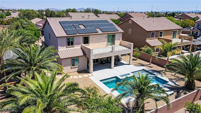 6489 Crest Estates St, Las Vegas, NV 89131 - back of property with a fenced backyard, stucco siding, roof mounted solar panels, and a tiled roof