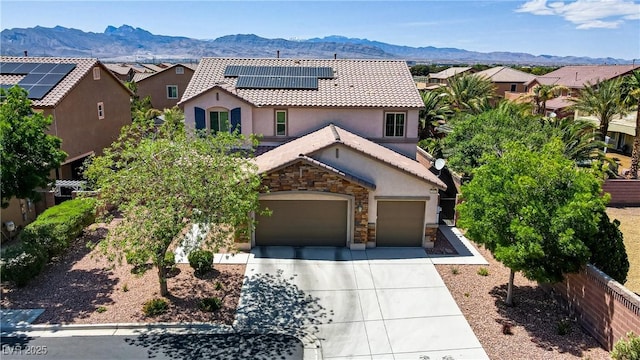 6489 Crest Estates St, Las Vegas, NV 89131 - mediterranean / spanish-style home featuring a mountain view, driveway, stucco siding, a tiled roof, and roof mounted solar panels