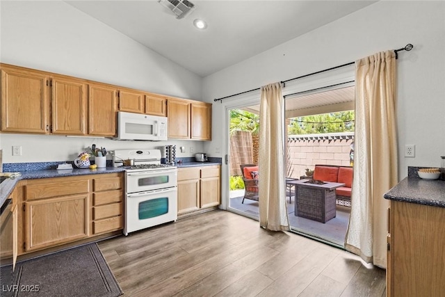 10352 Natural Springs Ave, Las Vegas, NV 89129 - kitchen featuring white appliances, light wood-type flooring, dark countertops, and high vaulted ceiling