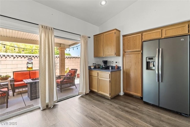 10352 Natural Springs Ave, Las Vegas, NV 89129 - kitchen with stainless steel refrigerator with ice dispenser, vaulted ceiling, wood finished floors, ornate columns, and dark countertops