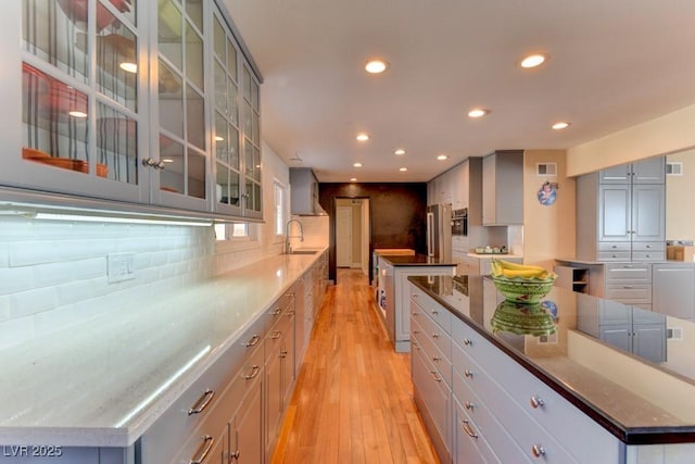 1818 Waldman Ave, Las Vegas, NV 89102 - kitchen featuring a large island, recessed lighting, gray cabinetry, light wood-style flooring, and glass insert cabinets
