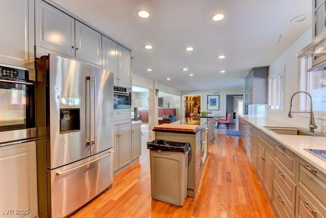 1818 Waldman Ave, Las Vegas, NV 89102 - kitchen with high end fridge, wall oven, light wood-style flooring, recessed lighting, and a kitchen island