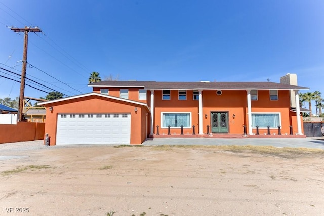 1818 Waldman Ave, Las Vegas, NV 89102 - view of front of house with stucco siding, french doors, a garage, and a chimney