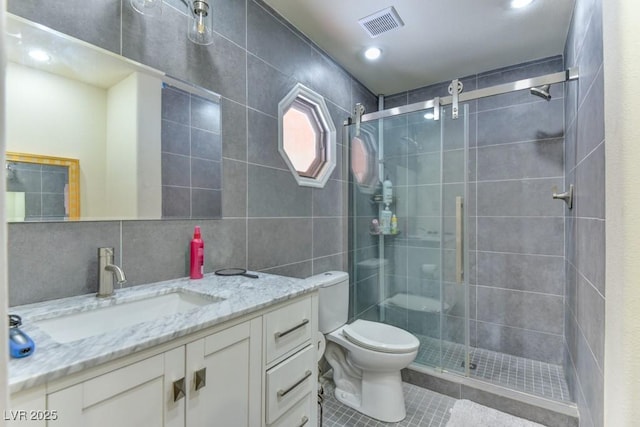 1818 Waldman Ave, Las Vegas, NV 89102 - full bathroom featuring tile patterned flooring, vanity, a shower stall, tile walls, and decorative backsplash