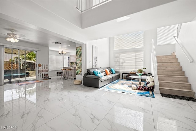 5332 Desert Blossom Rd, Las Vegas, NV 89107 - living room with stairs, marble tiled flooring, a ceiling fan, and a high ceiling