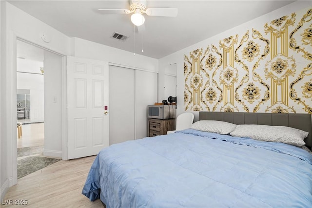 5332 Desert Blossom Rd, Las Vegas, NV 89107 - bedroom with light wood-style floors, a closet, and a ceiling fan