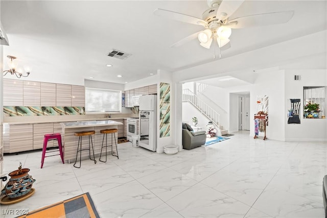 5332 Desert Blossom Rd, Las Vegas, NV 89107 - living room featuring stairs, light marble finish floors, ceiling fan, recessed lighting, and a chandelier