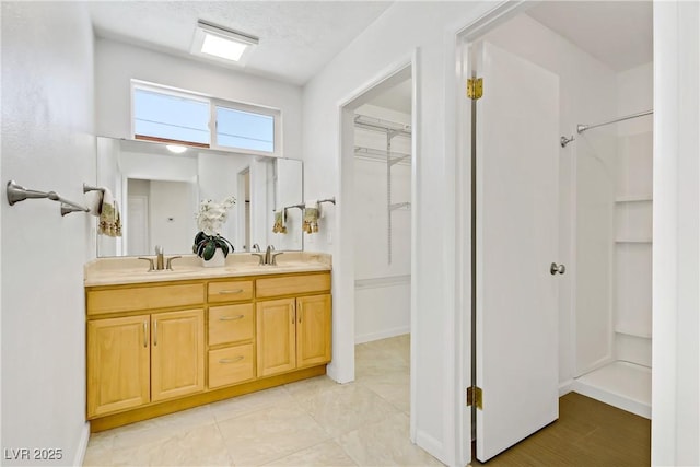 6358 Meadow Lark Ln, Las Vegas, NV 89103 - full bath with double vanity, a spacious closet, tile patterned floors, and a shower