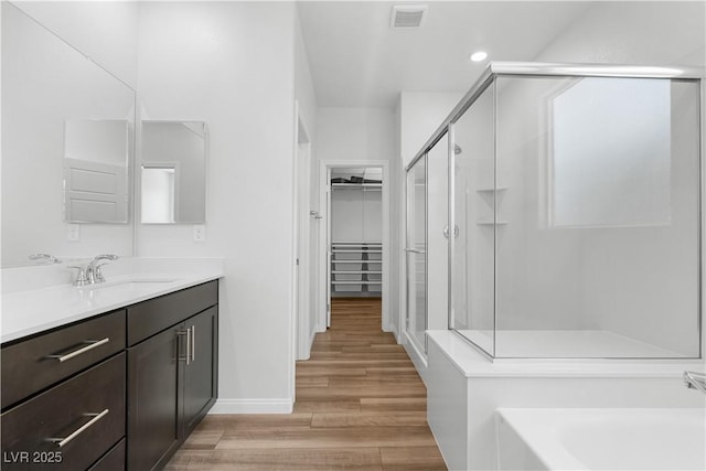 5936 Bruselas St, Las Vegas, NV 89113 - full bath featuring a shower stall, vanity, a spacious closet, wood finished floors, and a bath