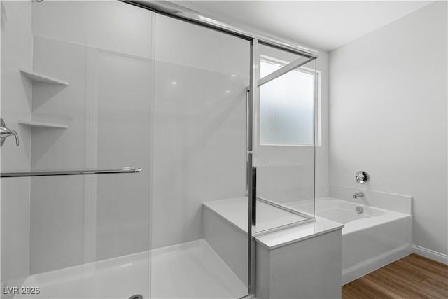 5936 Bruselas St, Las Vegas, NV 89113 - bathroom featuring a shower stall, a garden tub, and wood finished floors