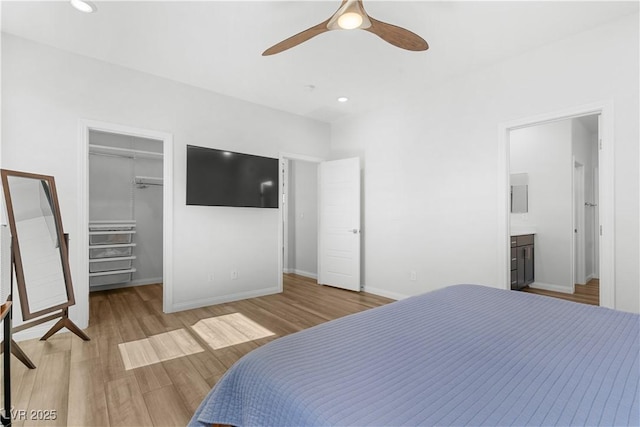 5936 Bruselas St, Las Vegas, NV 89113 - bedroom with a spacious closet, wood finished floors, a closet, ensuite bathroom, and ceiling fan
