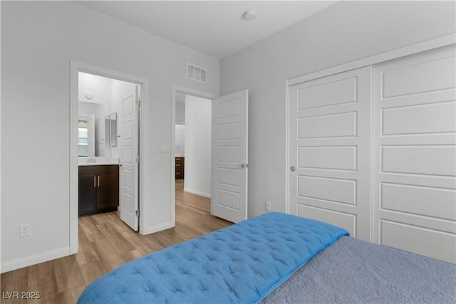 5936 Bruselas St, Las Vegas, NV 89113 - bedroom with light wood-style floors and connected bathroom