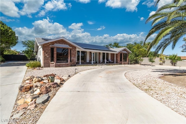 5486 Alfred Dr, Las Vegas, NV 89108 - ranch-style home featuring curved driveway, covered porch, brick siding, and solar panels