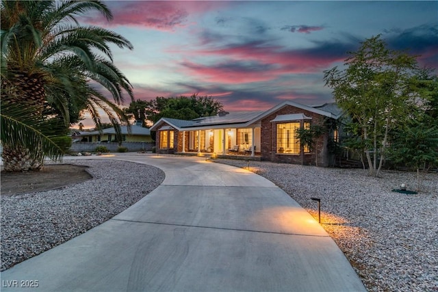 5486 Alfred Dr, Las Vegas, NV 89108 - ranch-style home featuring curved driveway, roof mounted solar panels, covered porch, and brick siding