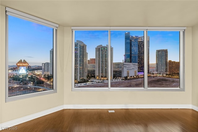 222 Karen Ave Unit 1702, Las Vegas, NV 89109 - unfurnished room with a view of skyline, wood finished floors, and healthy amount of natural light
