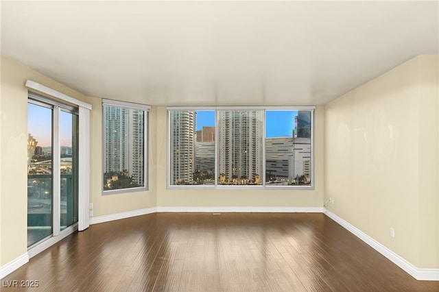 222 Karen Ave Unit 1702, Las Vegas, NV 89109 - spare room with dark wood-style flooring, a city view, and plenty of natural light