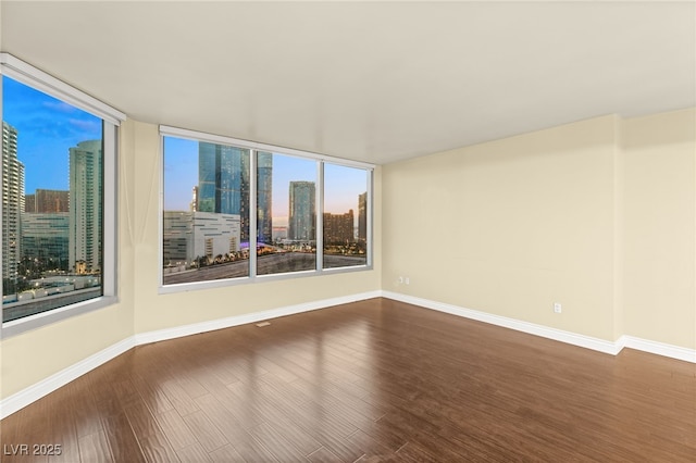 222 Karen Ave Unit 1702, Las Vegas, NV 89109 - spare room with wood finished floors, a skyline view, and plenty of natural light