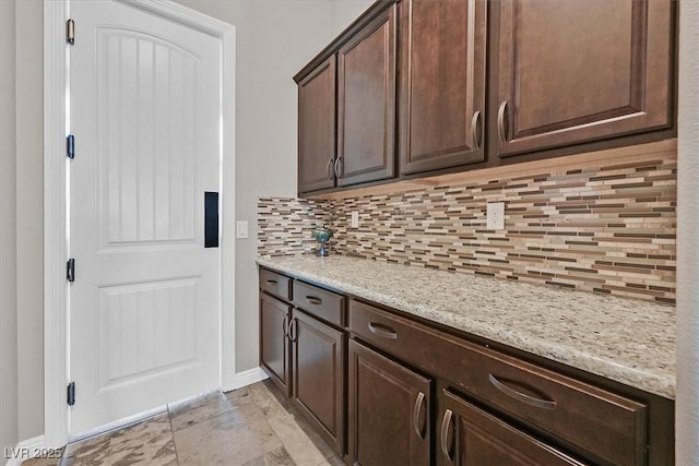 6208 W Rome Blvd, Las Vegas, NV 89131 - kitchen featuring decorative backsplash, dark brown cabinets, and light stone countertops