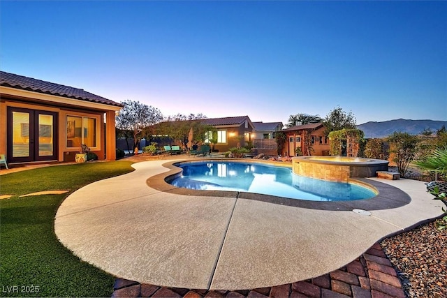 6208 W Rome Blvd, Las Vegas, NV 89131 - pool at dusk featuring a patio area, a yard, a mountain view, and a pool with connected hot tub