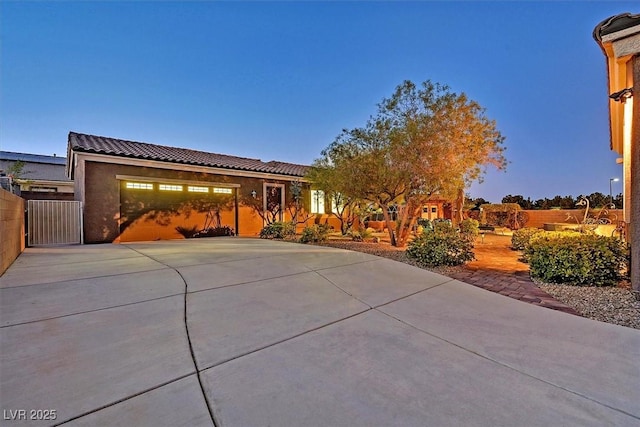 6208 W Rome Blvd, Las Vegas, NV 89131 - view of front facade featuring concrete driveway, an attached garage, a tiled roof, and stucco siding