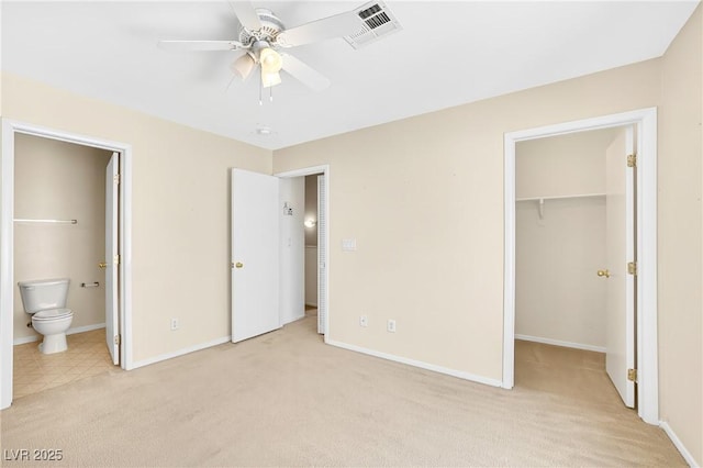 2558 Lazy Saddle Dr, Henderson, NV 89002 - unfurnished bedroom featuring light colored carpet, a spacious closet, connected bathroom, a closet, and a ceiling fan