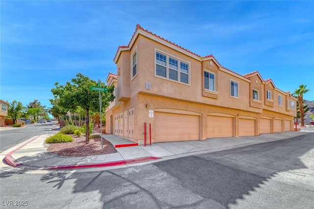 105 Lighthouse Dr Unit 105, Boulder City, NV 89005 - view of front of house featuring stucco siding, a tile roof, and a garage