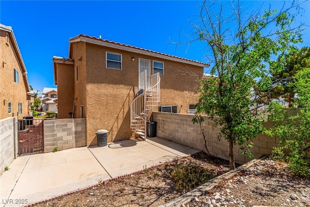 8041 Astrology Ct Unit 201, Las Vegas, NV 89128 - rear view of property featuring stucco siding, a fenced backyard, a tile roof, a patio area, and stairway