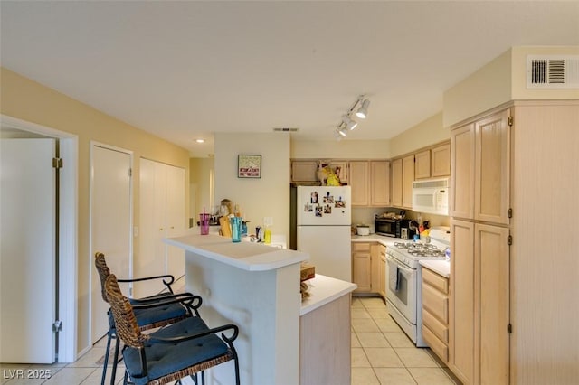 5415 W Harmon Ave Unit 2075, Las Vegas, NV 89103 - kitchen featuring white appliances, a breakfast bar, light tile patterned flooring, and light brown cabinetry