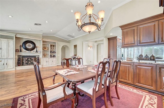 5224 Painted Lakes Way, Las Vegas, NV 89149 - dining space featuring vaulted ceiling, ornamental molding, light wood-type flooring, a chandelier, and arched walkways