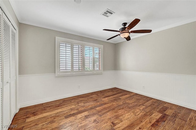 5224 Painted Lakes Way, Las Vegas, NV 89149 - unfurnished bedroom featuring wood finished floors, a closet, ornamental molding, a ceiling fan, and wainscoting