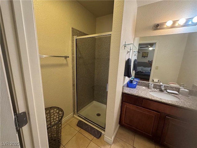 5499 Indian River Dr Unit 356, Las Vegas, NV 89103 - bathroom featuring tile patterned flooring, ensuite bath, a shower stall, a textured wall, and vanity