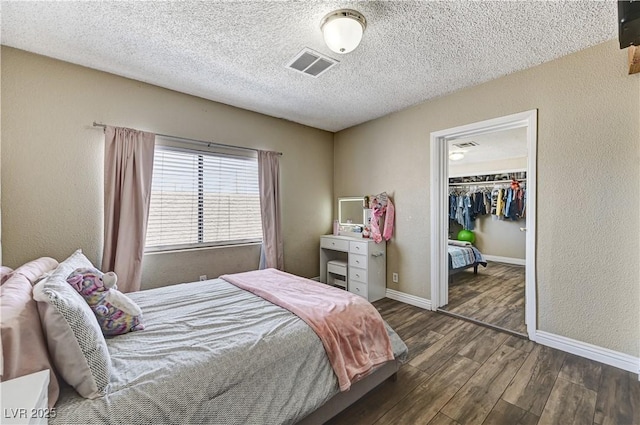 744 Mcknight St, Las Vegas, NV 89101 - bedroom with wood finished floors, a textured ceiling, a walk in closet, and a closet