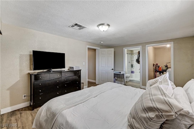 744 Mcknight St, Las Vegas, NV 89101 - bedroom with light wood-style flooring, connected bathroom, and a textured ceiling