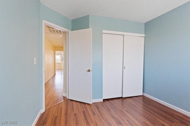 1711 Ember Glow Cir, Las Vegas, NV 89119 - unfurnished bedroom featuring wood finished floors, a closet, and a textured ceiling