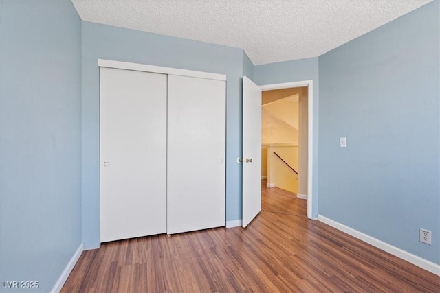 1711 Ember Glow Cir, Las Vegas, NV 89119 - unfurnished bedroom featuring wood finished floors, a closet, and a textured ceiling