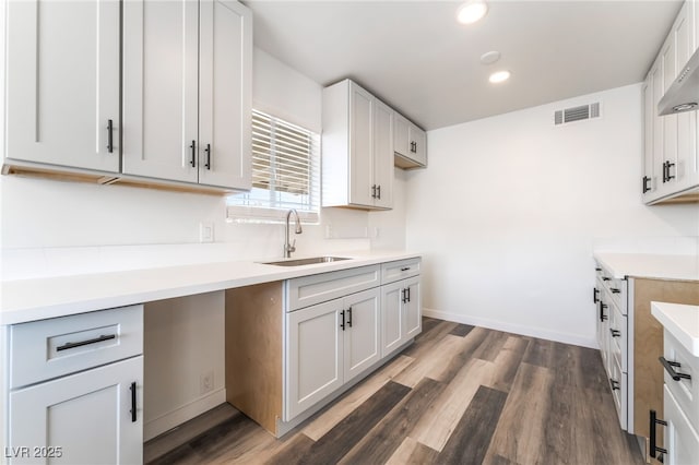 600 Berry Cir, Las Vegas, NV 89107 - kitchen with wood finished floors, recessed lighting, light countertops, and wall chimney range hood