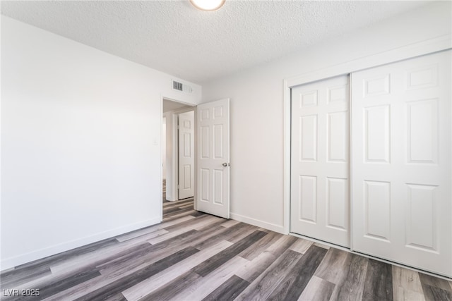 600 Berry Cir, Las Vegas, NV 89107 - unfurnished bedroom with wood finished floors, a textured ceiling, and a closet