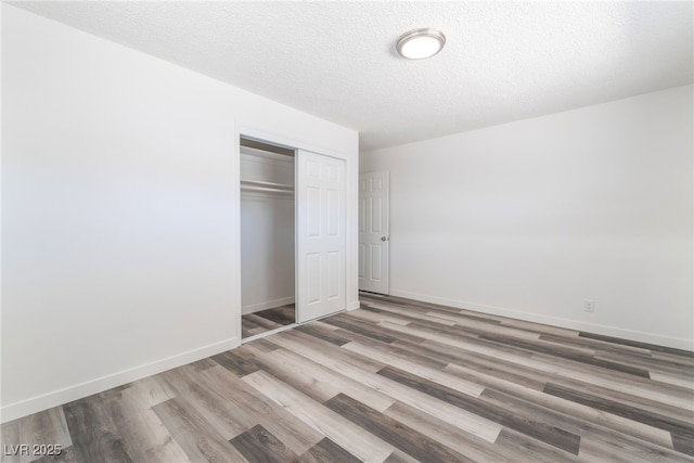 600 Berry Cir, Las Vegas, NV 89107 - unfurnished bedroom with wood finished floors, a closet, and a textured ceiling