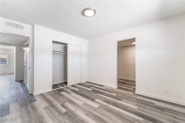 600 Berry Cir, Las Vegas, NV 89107 - unfurnished bedroom featuring wood finished floors, a closet, and a textured ceiling