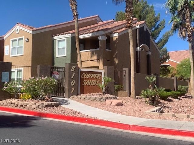 8101 W Flamingo Rd Unit 1102, Las Vegas, NV 89147 - view of front of home with stucco siding, a gate, and a tiled roof