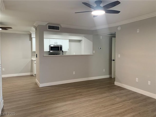 8101 W Flamingo Rd Unit 1102, Las Vegas, NV 89147 - unfurnished living room featuring a ceiling fan, ornamental molding, and wood finished floors