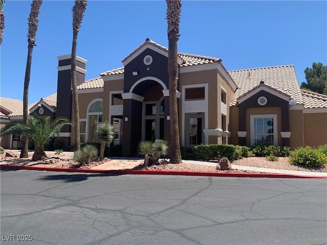 8101 W Flamingo Rd Unit 1102, Las Vegas, NV 89147 - view of front of property featuring stucco siding, a tiled roof, and a chimney