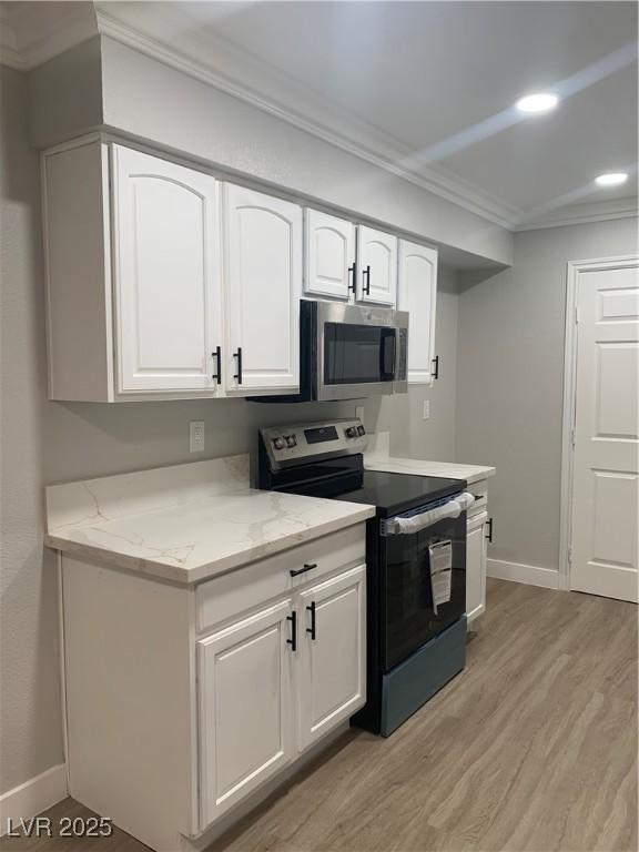 8101 W Flamingo Rd Unit 1102, Las Vegas, NV 89147 - kitchen with appliances with stainless steel finishes, ornamental molding, light wood-style flooring, white cabinetry, and light stone counters
